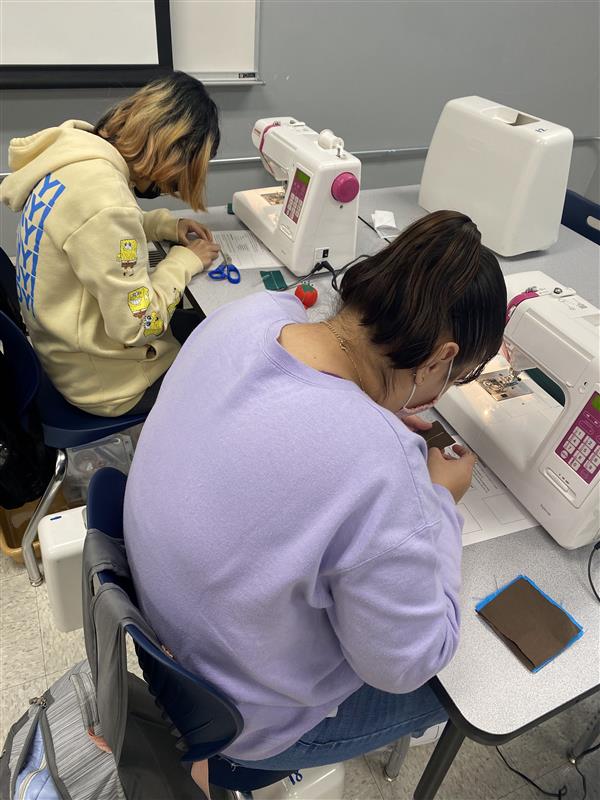 Students working on sewing skills.