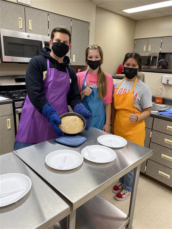 Students show their baking results.