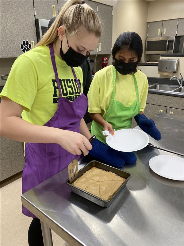 Students dishing up baked goods.